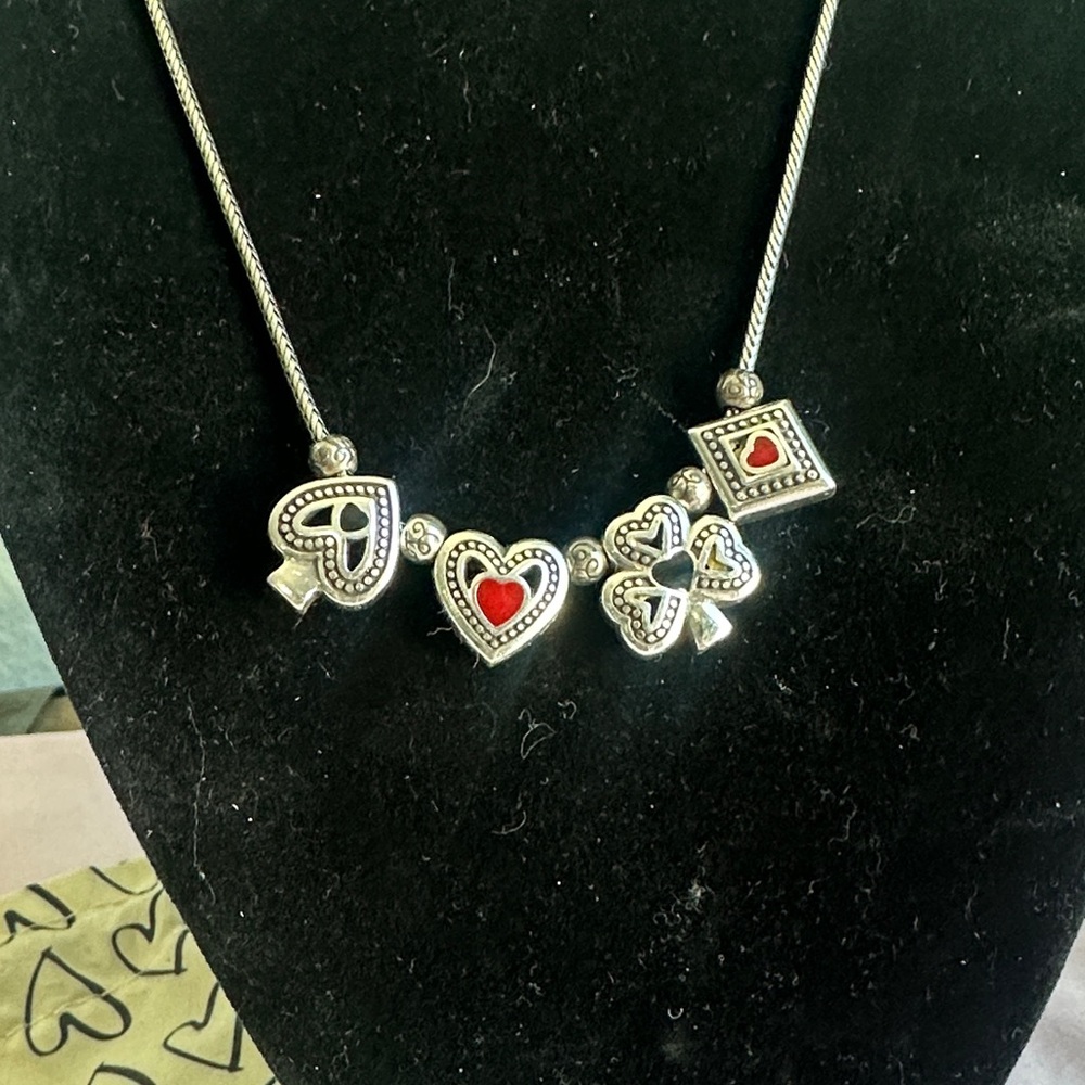 Brighton “DEAL ME IN “  Silver Necklace with Red and black charms .
NWOT